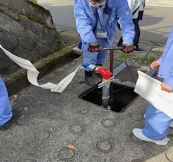 配水池の災害用給水栓から注水する様子の写真