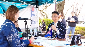 ラジオ生放送を行う区長の写真